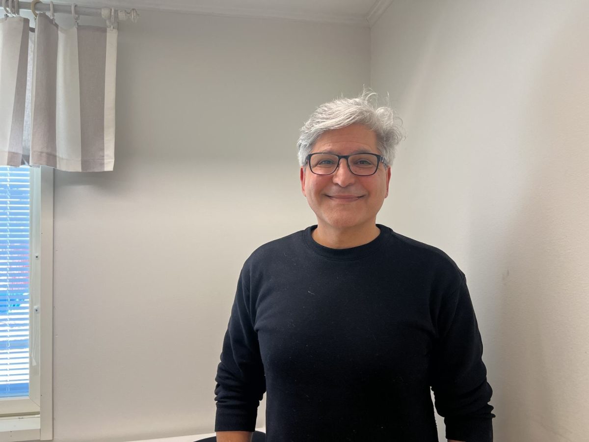 Michael Shahidiar hymyilee omassa toimistossaan.